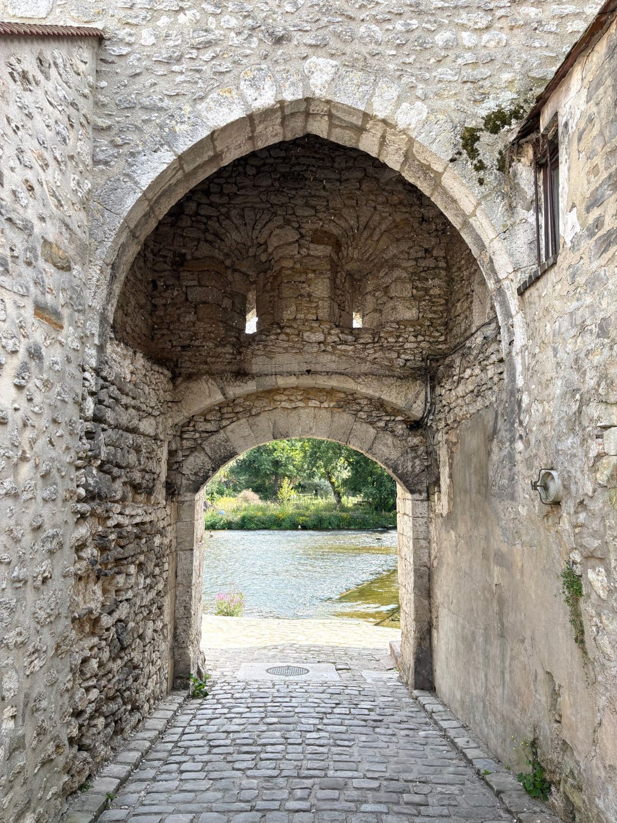 Porte médiévale en pierre ouvrant sur le Loing